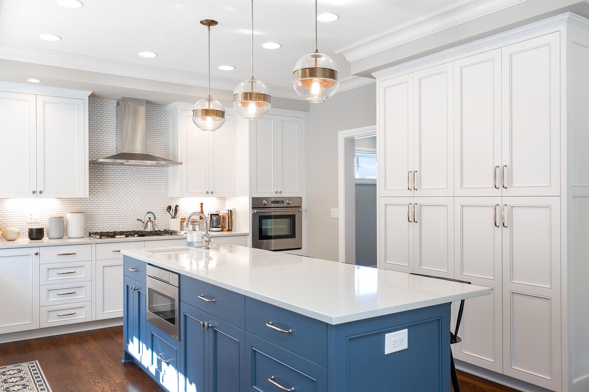 Modern kitchen remodel with white custom cabinets and blue island