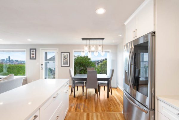 Open white kitchen with a granite island facing the dining room