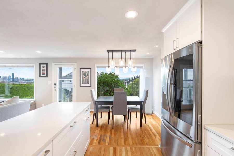 Open white kitchen with a granite island facing the dining room