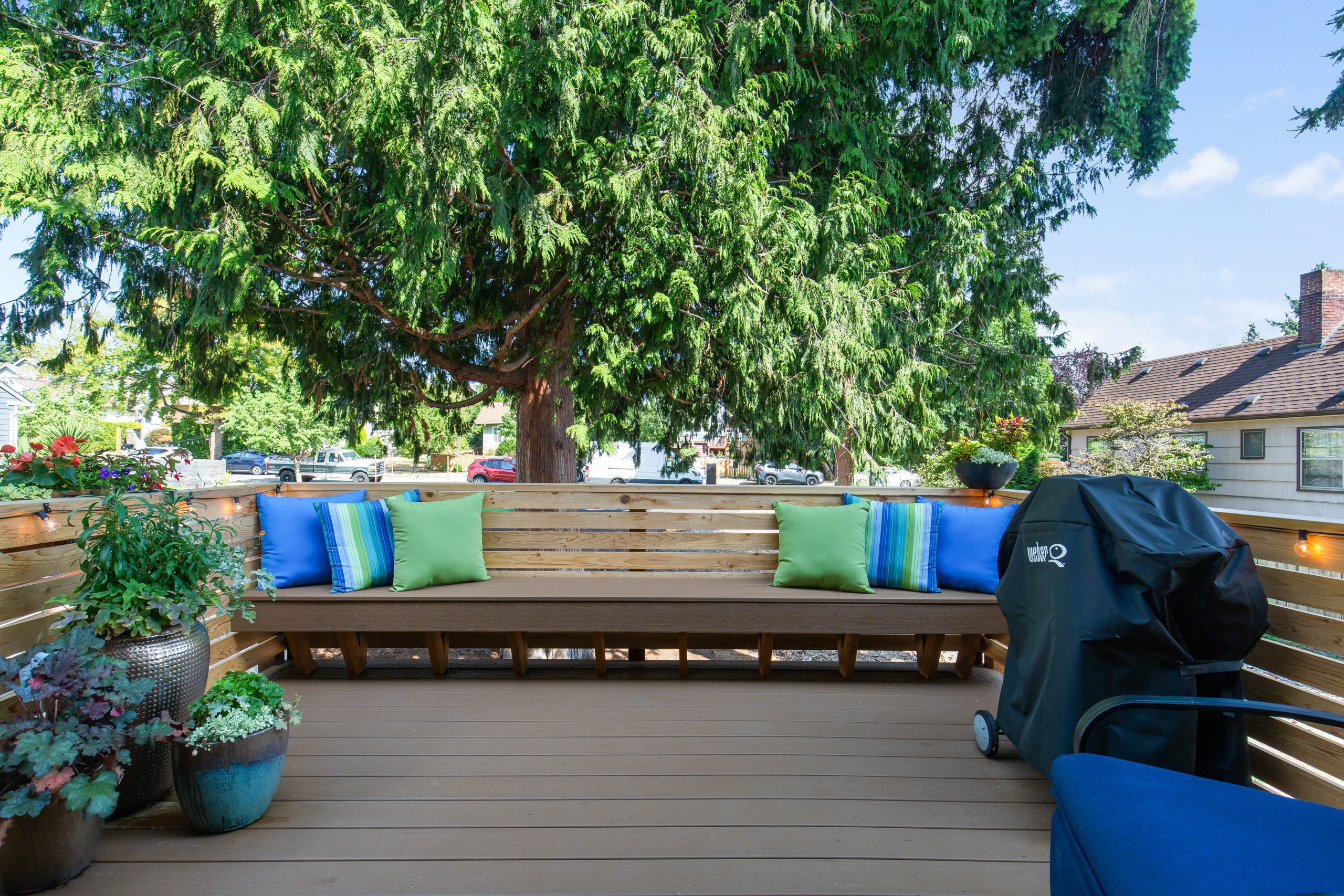 Backyard deck with long bench seating and trees