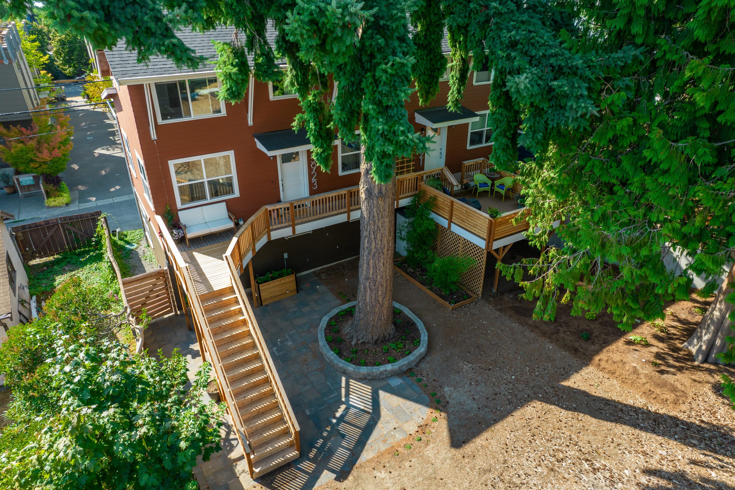 Aerial view of a raised wooden deck and large backyard tree