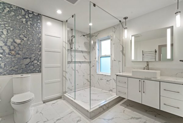 White marble bathroom with rainfall shower and white cabinets