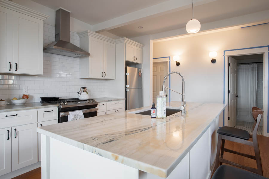 Close up on kitchen island with white marble and cabinets