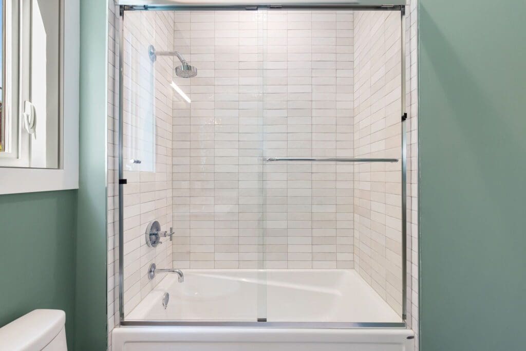 6733 46th Ave SW, Seattle WA_0026 Tub and shower combo featuring subway tiles and glass shower doors.